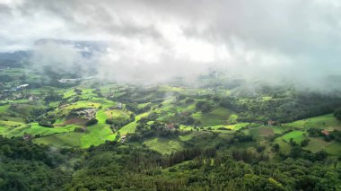 Çarpıcı bir hava manzarası canlı yeşillik ve bulutlu gökyüzünü gösterir. Doğayı keşfetmek ve takdir etmek için mükemmeldir.