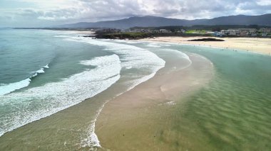 Göz kamaştırıcı hava manzarası sunar dalgalar güzel, kumlu bir sahile nazikçe vurur resimli bir arkaplanın ortasında
