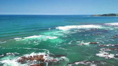 Kristal berrak turkuaz suları ve yemyeşil sularıyla sakin bir sahil şeridinin nefes kesici manzarasına hayret edin.