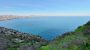 Sakin ve kristal mavi sular üzerinde çarpıcı panoramik görüntülere yol açan nefes kesici bir kıyı yolu.