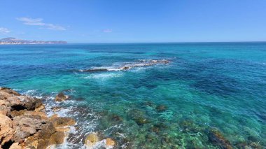 Dramatik kayalık kıyı şeritlerine karşı sakin, pırıl pırıl turkuaz suların nefes kesici ve çarpıcı manzarasını keşfedin