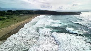 Nefes kesici bir hava manzarası sakin sahil dalgalarını ve güzel sahil şeridi boyunca yemyeşil alanları gösteriyor.