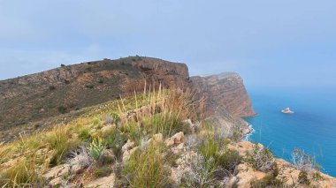 Bereketli bitki örtüsüyle çevrili nefes kesen sahil uçurumlarını keşfedin. Huzurlu ve resimli bir okyanus manzarası sunuyor.