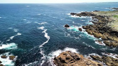 Kıyı şeridinin nefes kesici hava manzarası, kayalık oluşumlara çarpan turkuaz dalgalar..