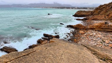 Kıyı manzarası dalgaların kayalıklara çarptığını gösteriyor. Herkes için güzel ve sakin bir atmosfer yaratıyor.