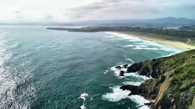 Görkemli uçurumlar ve canlı okyanus dalgalarıyla çarpıcı bir kıyı manzarasını gösteren hava görüntüleri.