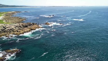 Havadan çekilen görüntülerde kıyıya hafifçe vuran dalgalarla kayalık bir sahil şeridi nefes kesici görünüyor.