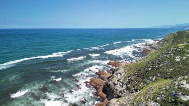 Çarpıcı deniz manzarası dalgaların engebeli kayalıklara çarptığını gösteriyor.