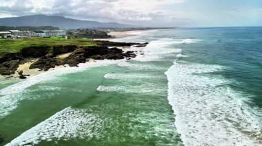 Karşınızda çarpıcı bir hava manzarası canlı okyanus dalgaları kıyı boyunca yemyeşil kayalıklara çarpıyor.