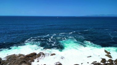 Nefes kesen kıyı manzarası canlı, masmavi sular ve kayalara çarpan köpüklü dalgalar sergiliyor.