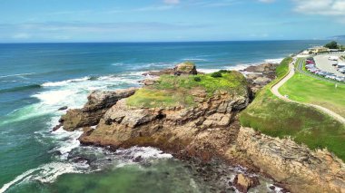 Nefes kesen dalgaların hava manzarası kayalık kıyılara ve yemyeşil yeşilliklere şiddetle çarpıyor.