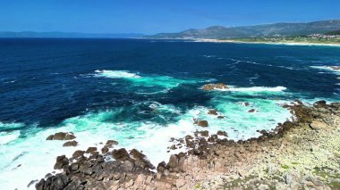 Nefes kesici bir okyanus kıyısı manzarası. Güzel canlı turkuaz suları ve kayalık kıyıları var.