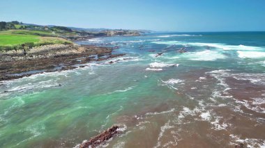 Kıyı manzarası göz kamaştırıcı turkuaz sulara ve parlak mavi gökyüzü altında eşsiz kaya oluşumlarına sahiptir.