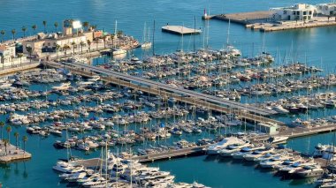 Lüks yatlar ve pitoresk sularla dolup taşan canlı bir marinanın nefes kesici hava görüntüsü.