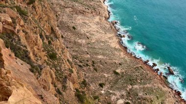 Çarpıcı, pitoresk kayalık bir sahil şeridi kristal turkuvaz suları ve uzak, görkemli kaya oluşumları içerir.