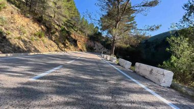 Güzel, dolambaçlı dağ yolu, bereketli ağaçlar ve yuvarlanan tepelerle çevrili, heyecan verici bir keşif için mükemmel.