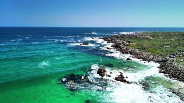 Uçsuz bucaksız mavi gökyüzünün altında engebeli bir kıyı şeridinin turkuaz sularla buluşması çarpıcı bir deneyim.