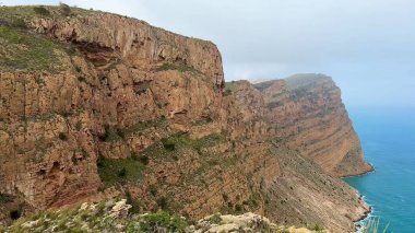 Görkemli ve yüksek kıyı kayalıkları aşağıdaki güzel turkuaz suların huzurlu ve nefes kesici manzarasını sağlar.