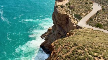 Canlı, turkuaz bir okyanusa bakan yüksek bir uçurumun nefes kesici manzarası doğa severler için ideal.