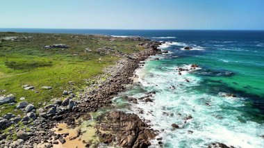 Bu çarpıcı kıyı manzarasında kayalık kıyı şeridinin nefes kesici güzelliğini ve okyanusun canlı renklerini yakalayın.