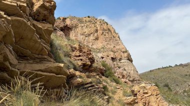 Nefes kesici bir manzara sergiler kayalık kayalıkları ve güzel tepeleri berrak bir gökyüzünün altında parıldayan denizi.