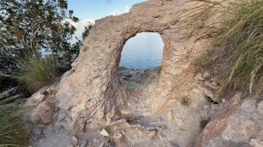 Huzurlu bir kaya kemeri çarpıcı su manzarası, doğa severler ve maceraperest gezginler için mükemmel.