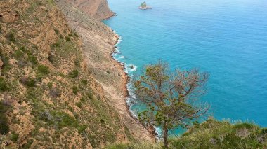 Bu pitoresk kıyı manzarasında sakin turkuaz sulara bakan nefes kesici uçurumlar.