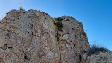 Çarpıcı görüntüler, yukarıda yükselen nefes kesici uçurumları ve güzel bir kıyı şeridi boyunca uzanan sakin deniz manzaralarını tasvir eder.