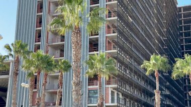 Pürüzsüz, modern bir gökdelen inşaatı devam ediyor. Şehir merkezinde yüksek palmiye ağaçları ile çevrili.