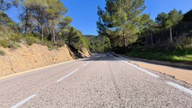 Dönek bir yol boyunca canlı ağaçlarla ve dingin bir dağ zeminiyle çarpıcı manzaralar boyunca bir yolculuğa çıkın.