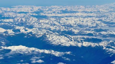 Nefes kesen bir hava manzarası sersemletici, görkemli, karla kaplı dağlar berrak mavi gökyüzünün altında.