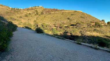 Bereketli, yuvarlanan tepelerle çevrili sakin ve huzurlu bir yol, deniz manzarası sunuyor.