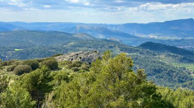 Nefes kesici panoramik manzara, dingin bir gökyüzünün altında heybetli dağlarla kaynaşan canlı bir yeşillik sunar.