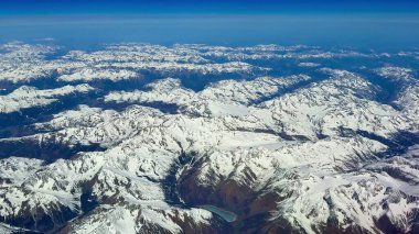 Bu nefes kesici hava manzarası göz kamaştırıcı ve görkemli kar kaplı dağ zirvelerini berrak mavi gökyüzünün altında sergiliyor.