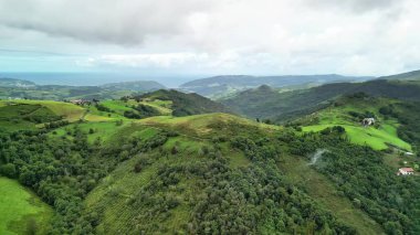 Kesinlikle nefes kesici bir hava manzarası huzurlu bir kıyı manzarası boyunca canlı yeşil tepeleri yakalar.