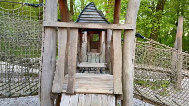 Ahşap ip köprüsü olan hoş bir oyun alanı. Çocuklar için oyun ve keşif için ideal.