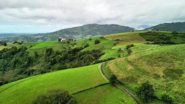 Muhteşem hava manzarası, yuvarlanan yeşil tepeler, dönen yollar, hepsi güzel bulutlu bir gökyüzünün altında.