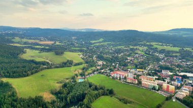 Göz kamaştırıcı bir hava manzarası yemyeşil ve büyüleyici kasabayı güzel bir şekilde yakalıyor. Yuvarlanan tepelerin arasında.