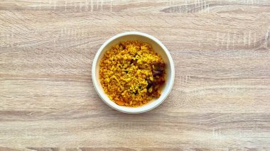 Lezzetli bir yemek için mükemmel baharatlar, fasulyeler ve tuzlu parçalar içeren canlı bir kase sarı pirinç..