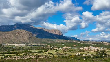 Şaşırtıcı derecede güzel bir manzara görkemli dağlar ve çarpıcı bir gökyüzünün altında canlı, bereketli bir manzara.