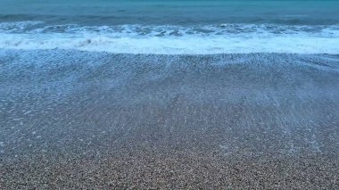 Kendini dingin ve dingin bir güzelliğe daldır. Hafif dalgaların alacakaranlıkta yavaşça kıyıya vurması.