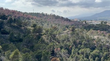 Göz kamaştırıcı insansız hava aracı manzarasında canlı yemyeşil evlerin arasına yerleştirilmiş konforlu evlerin yanında görkemli dağlar sergileniyor.