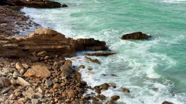 Kayalık kıyı şeridine çarpan güçlü dalgaların çarpıcı görüntüsü, doğal huzuru yakalıyor.