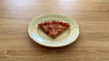 Lezzetli ve cezbedici bir pizza dilimi dekoratif bir tabakta güzelce dinleniyor, her yerdeki yemek severler için ideal.