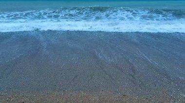 Alacakaranlık gökyüzü altındaki plaj dalgalarının huzur verici güzelliğini tecrübe et, rahatlama ve meditasyon için mükemmel..