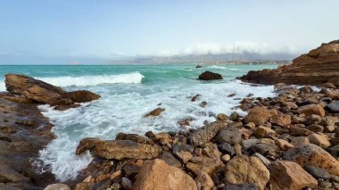 Yumuşak dalgaların nefes kesici ve sakin görüntüsü düzenli olarak deniz boyunca kayalık oluşumlara çarpar.