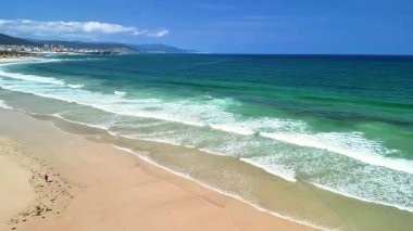 Berrak mavi suların ve parlak güneşli bir gökyüzünün altında süzülen nazik dalgaların olduğu sakin bir tropikal sahil hayal edin.