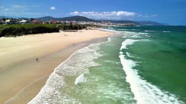 Göz kamaştırıcı bir sahil manzarası kumlu sahilleri ve dalgalı okyanus dalgalarını gözler önüne seriyor.