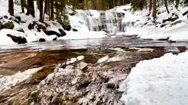 Nefes kesen ve güzel bir şelale zarif bir şelaleyle sersemletici bir kar manzarasında kış boyunca ilerliyor.