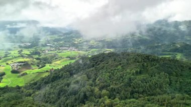 Göz kamaştırıcı bir hava manzarası canlı yeşil tepeler, kabarık bulutlar ve güzel sakin kırsal manzaralar.